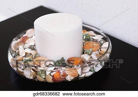 Close-up of a candle with shells in a bowl View Large Photo Image Stock Image - Close-up of a candle with shells in a bowl. Fotosearch