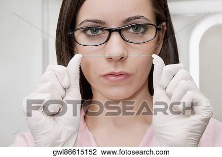 Close-up of a female dentist holding dental floss View Large Photo Image Stock Image - Close-up of a female dentist holding dental floss. Fotosearch