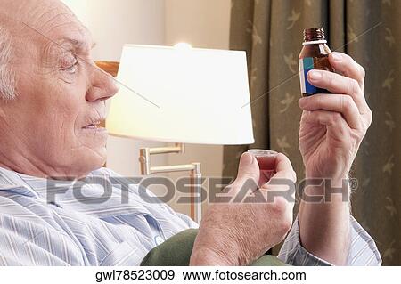 Close-up of a man taking medicine View Large Photo Image Stock Photo - Close-up of a man taking medicine. Fotosearch