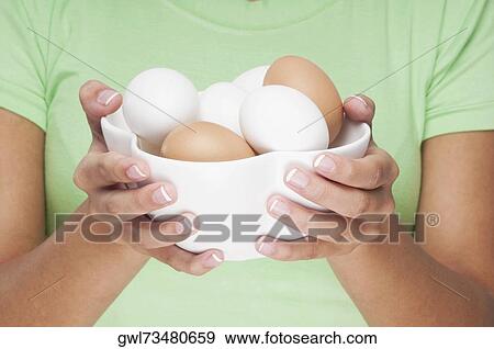 Close-up of a woman holding a bowl of eggs View Large Photo Image Stock Photo - Close-up of a woman holding a bowl of eggs . Fotosearch