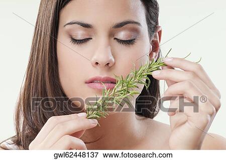 Stock Photo - Close-up of a woman smelling aroma herbs. Fotosearch