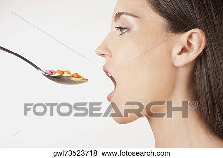 Close-up of a woman taking a spoonful of pills View Large Photo Image Stock Photo - Close-up of a woman taking a spoonful of pills. Fotosearch