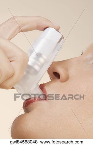 Close-up of a woman using an inhaler View Large Photo Image Stock Photo - Close-up of a woman using an inhaler. Fotosearch