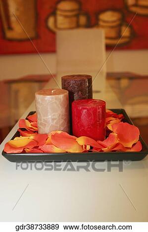 Stock Photo - Close-up of candles with petals on a tray. Fotosearch