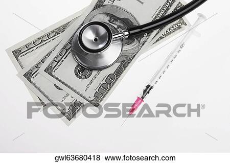 Stock Photo - Close-up of hundred dollar bills with a stethoscope and a syringe. Fotosearch