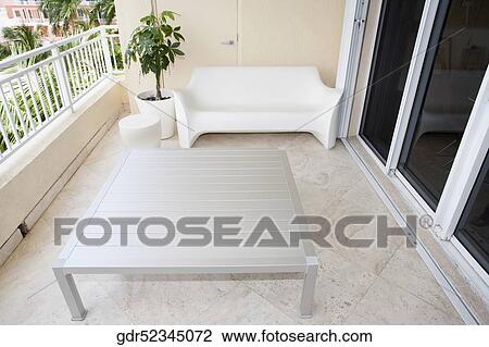 Couch and potted plant in the balcony of a house View Large Photo Image Stock Image - Couch and potted plant in the balcony of a house. Fotosearch