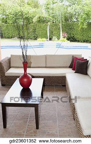 Stock Image - Couches in the porch of a house. Fotosearch