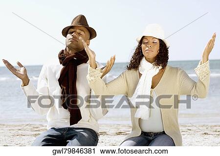 Couple meditating on the beach View Large Photo Image Stock Image - Couple meditating on the beach. Fotosearch