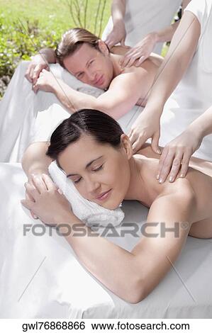 Couple receiving back massage from massage therapists View Large Photo Image Stock Photograph - Couple receiving back massage from massage therapists. Fotosearch