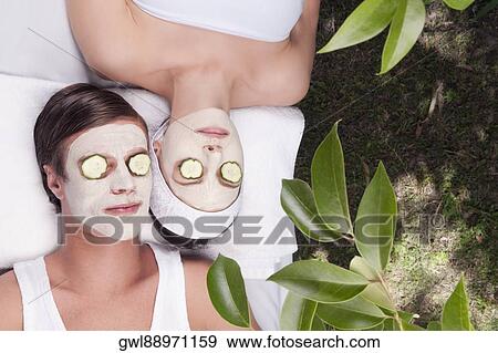Couple with face pack and cucumber slices on their eyes View Large Photo Image Stock Photo - Couple with face pack and cucumber slices on their eyes. Fotosearch