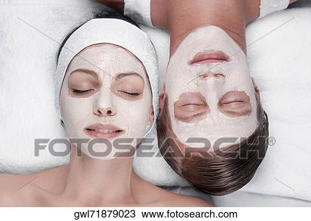 Stock Image - Couple with face pack on their faces. Fotosearch