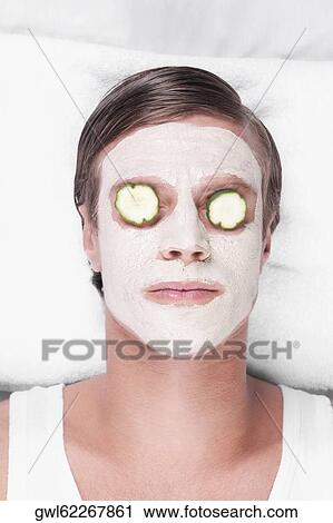 Stock Image - Cucumber slices on a man's eyes. Fotosearch