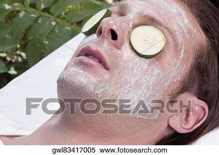 Stock Photography - Cucumber slices on a man's eyes. Fotosearch
