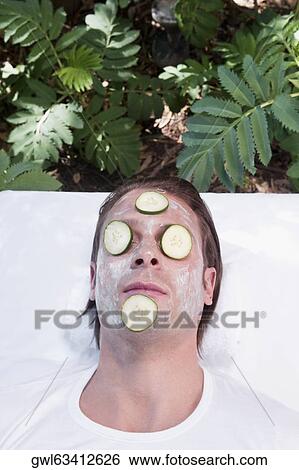 Cucumber slices on a man's face View Large Photo Image Stock Photograph - Cucumber slices on a man's face. Fotosearch
