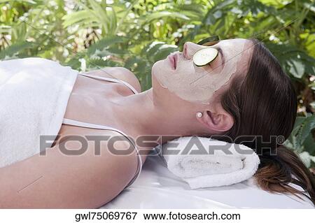 Cucumber slices on a woman's eyes View Large Photo Image Stock Photo - Cucumber slices on a woman's eyes. Fotosearch