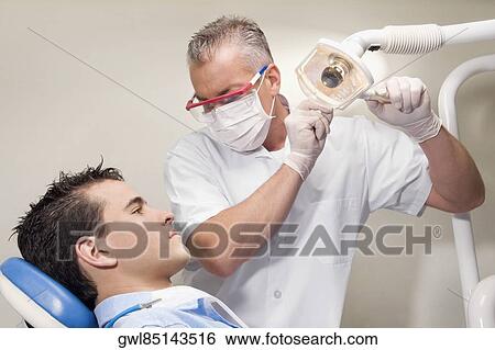 Stock Photograph - Dentist examining a patient. Fotosearch