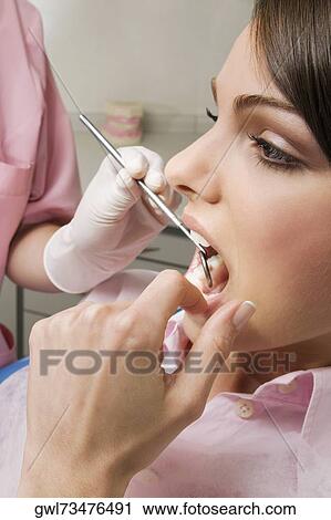 Dentist examining a woman's teeth View Large Photo Image Stock Image - Dentist examining a woman's teeth. Fotosearch