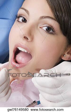 Dentist examining a woman's teeth View Large Photo Image Stock Image - Dentist examining a woman's teeth. Fotosearch
