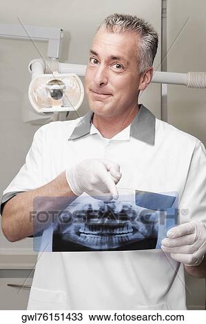 Dentist examining an X-Ray report View Large Photo Image Stock Image - Dentist examining an X-Ray report. Fotosearch