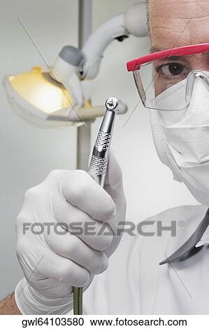 Dentist holding a dental drill View Large Photo Image Stock Image - Dentist holding a dental drill. Fotosearch