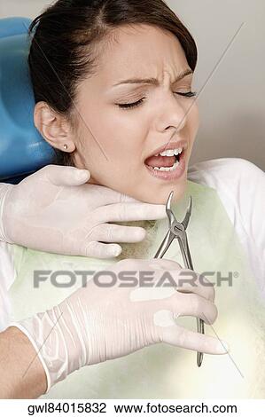 Dentist using pliers to pull out woman's teeth View Large Photo Image Stock Image - Dentist using pliers to pull out woman's teeth. Fotosearch