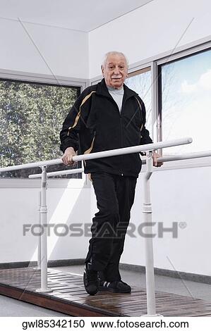 Disabled man practicing on a walker View Large Photo Image Stock Image - Disabled man practicing on a walker. Fotosearch