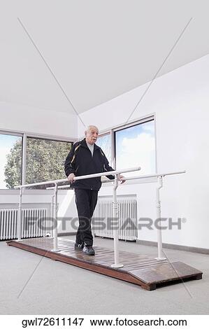 Disabled man practicing on a walker View Large Photo Image Stock Photo - Disabled man practicing on a walker. Fotosearch