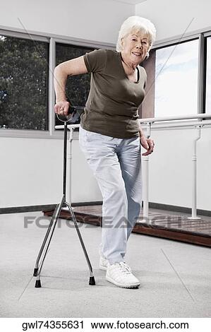 Disabled woman walking with a cane View Large Photo Image Stock Image - Disabled woman walking with a cane. Fotosearch