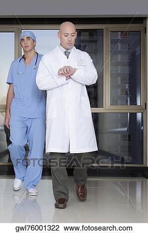 Doctor and a surgeon walking in the hospital corridor View Large Photo Image Stock Image - Doctor and a surgeon walking in the hospital corridor. Fotosearch