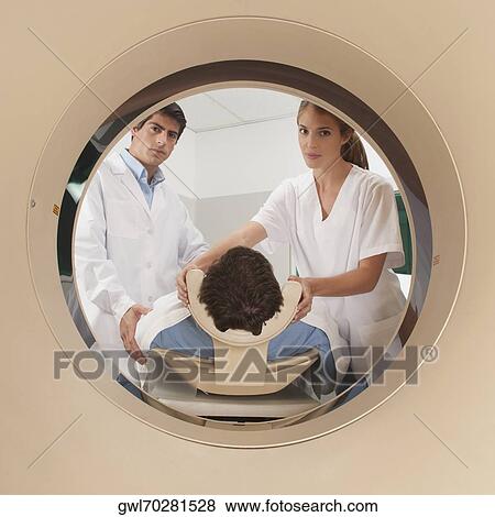 Doctor and nurse preparing a patient for MRI scan View Large Photo Image Stock Photo - Doctor and nurse preparing a patient for MRI scan. Fotosearch