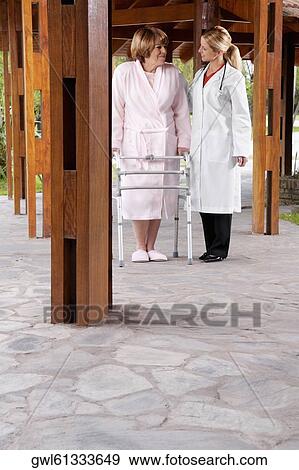 Doctor assisting a patient in walking in a rehabilitation centre View Large Photo Image Stock Photo - Doctor assisting a patient in walking in a rehabilitation centre. Fotosearch