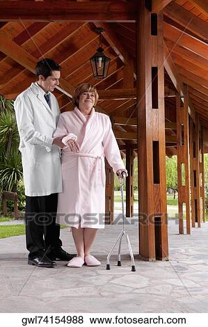 Doctor assisting a patient in walking in a rehabilitation centre View Large Photo Image Stock Photo - Doctor assisting a patient in walking in a rehabilitation centre. Fotosearch
