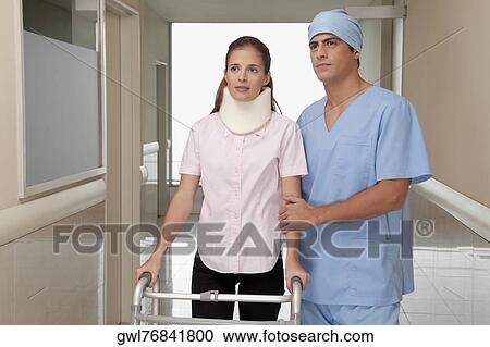 Doctor assisting a patient to walk in a hospital corridor View Large Photo Image Stock Image - Doctor assisting a patient to walk in a hospital corridor. Fotosearch