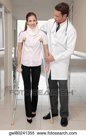 Doctor assisting a patient to walk in a hospital corridor View Large Photo Image Stock Photography - Doctor assisting a patient to walk in a hospital corridor. Fotosearch