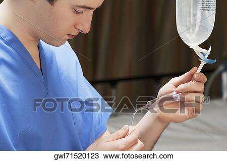 Doctor checking a saline drip View Large Photo Image Stock Image - Doctor checking a saline drip. Fotosearch