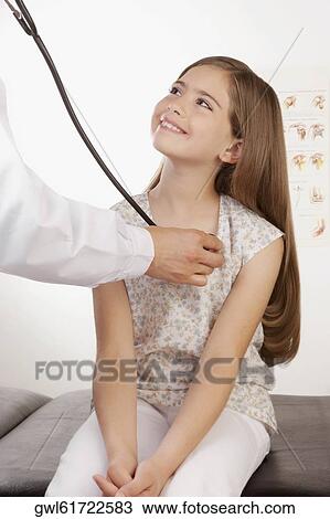 Doctor examining a girl with a stethoscope View Large Photo Image Stock Image - Doctor examining a girl with a stethoscope. Fotosearch