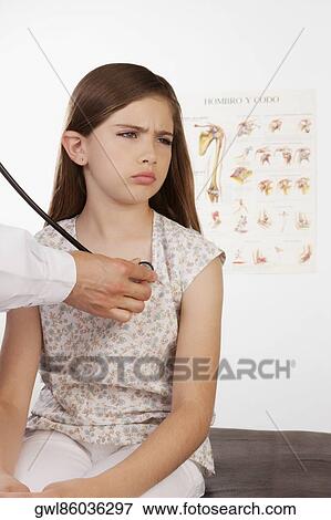 Doctor examining a girl with a stethoscope View Large Photo Image Stock Photo - Doctor examining a girl with a stethoscope. Fotosearch