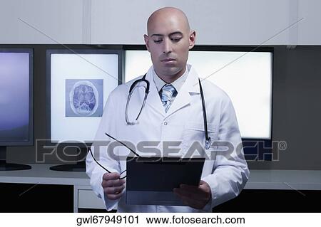 Doctor examining a medical report View Large Photo Image Stock Image - Doctor examining a medical report. Fotosearch