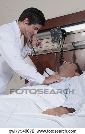 Doctor examining a patient in a hospital View Large Photo Image Stock Image - Doctor examining a patient in a hospital. Fotosearch