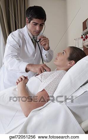 Doctor examining a woman View Large Photo Image Stock Photograph - Doctor examining a woman. Fotosearch