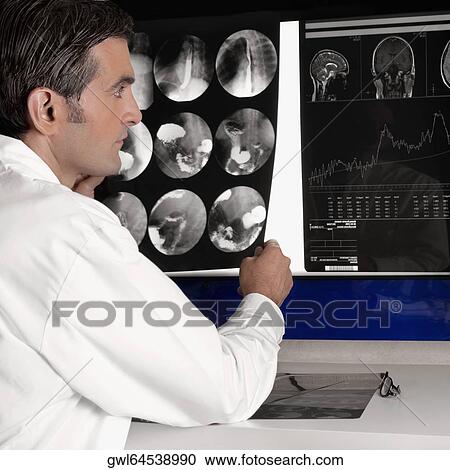 Doctor examining MRI report View Large Photo Image Stock Image - Doctor examining MRI report. Fotosearch