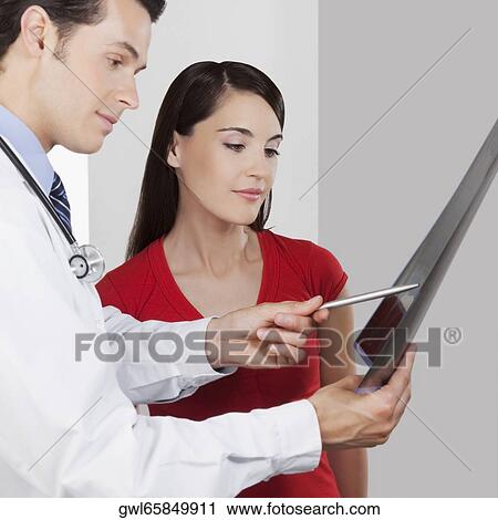Doctor explaining x-ray report to a patient View Large Photo Image Stock Image - Doctor explaining x-ray report to a patient. Fotosearch