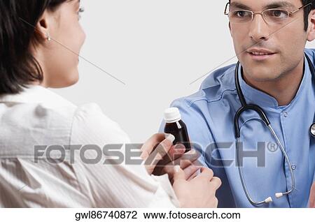 Stock Image - Doctor giving medicine to a patient. Fotosearch