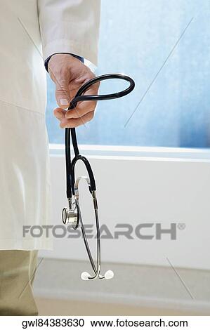 Stock Image - Doctor holding a stethoscope. Fotosearch