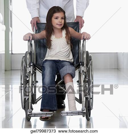 Doctor pushing a patient in a wheelchair View Large Photo Image Stock Image - Doctor pushing a patient in a wheelchair. Fotosearch