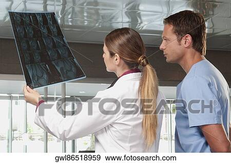 Doctor showing MRI scan to a male nurse View Large Photo Image Stock Photo - Doctor showing MRI scan to a male nurse. Fotosearch