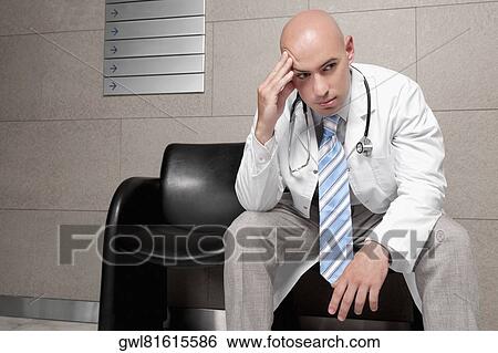 Doctor sitting on a chair and looking stressed View Large Photo Image Stock Photograph - Doctor sitting on a chair and looking stressed. Fotosearch