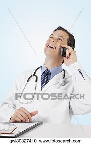 Doctor talking on a mobile phone View Large Photo Image Stock Image - Doctor talking on a mobile phone. Fotosearch