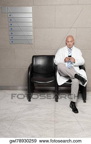 Doctor text messaging on a mobile phone View Large Photo Image Stock Photo - Doctor text messaging on a mobile phone. Fotosearch