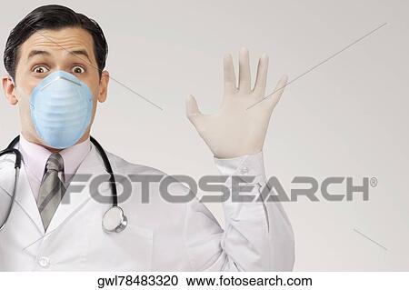 Doctor wearing a flu mask and gesturing View Large Photo Image Stock Image - Doctor wearing a flu mask and gesturing. Fotosearch